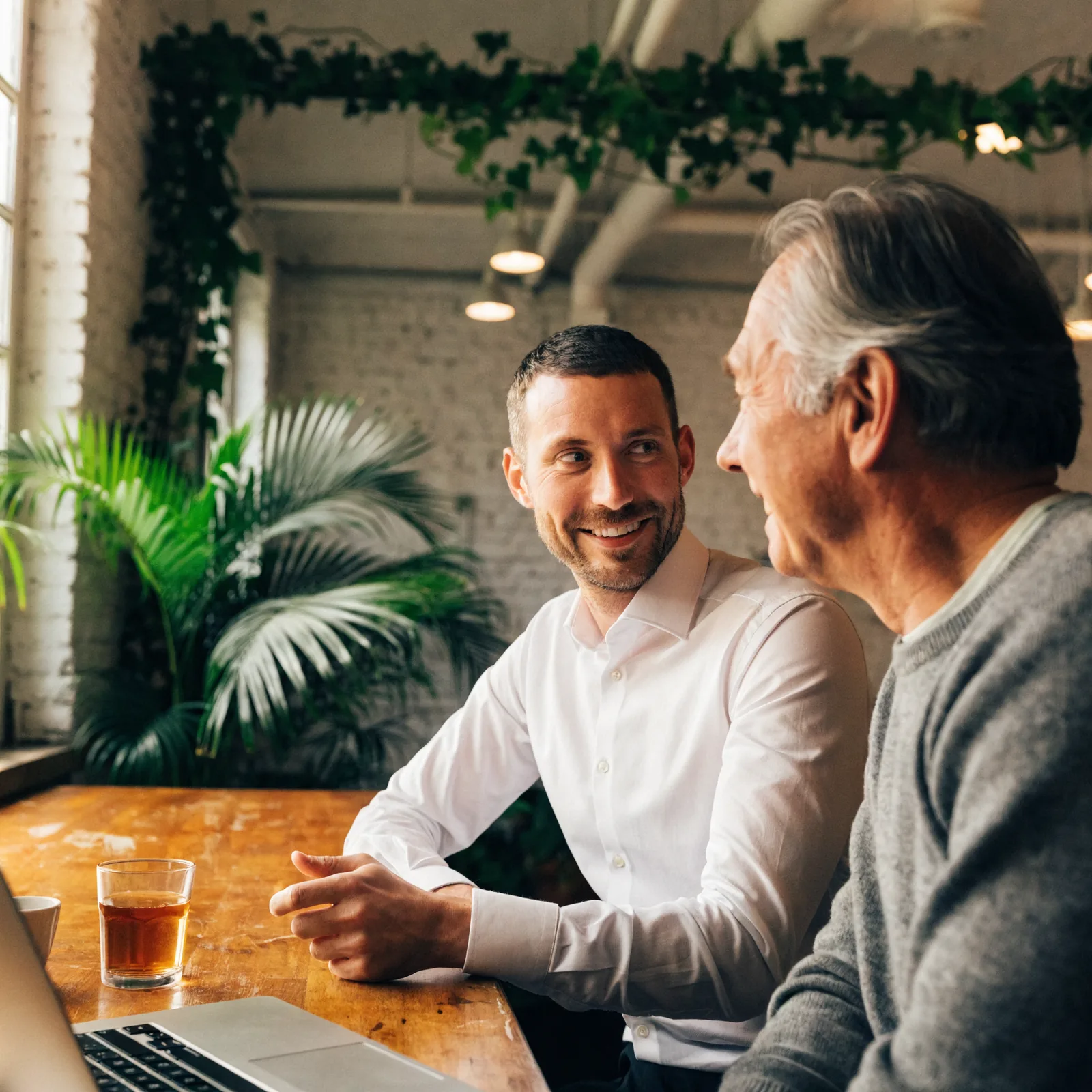 Adviseur van Energie Morgen in gesprek met een klant aan tafel, met een laptop tussen hen in