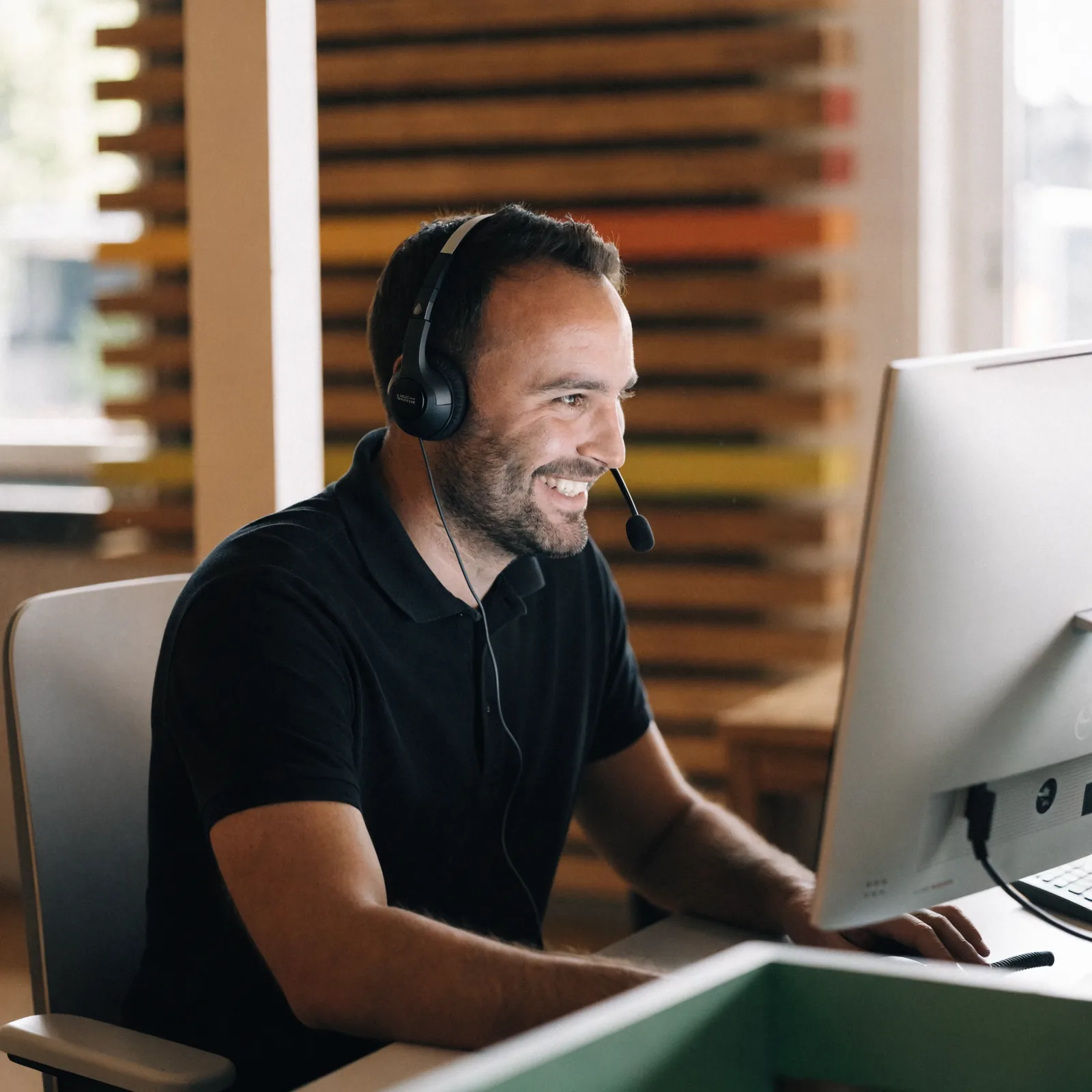 Medewerker van Energie Morgen met headset achter een beeldscherm, klaar om te ondersteunen
