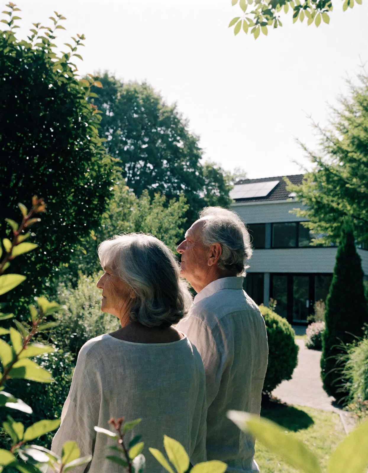 Ouder stel kijkt naar hun woning met zonnepanelen