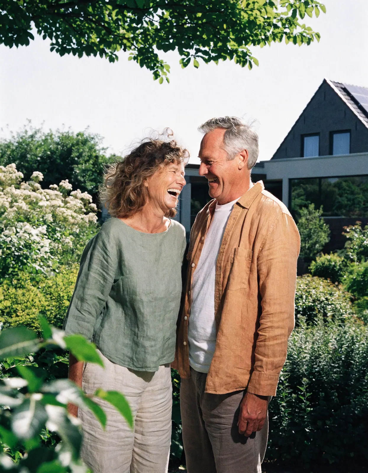 Stel lacht in de tuin bij hun woning