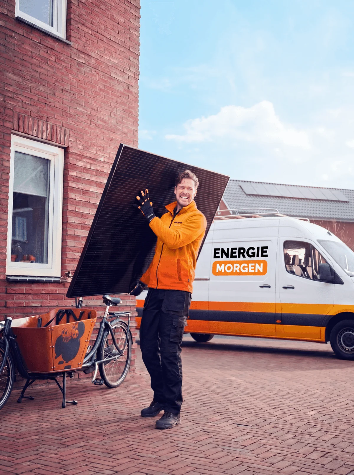Energie Morgen monteur draagt een zonnepaneel naast de bedrijfsbus
