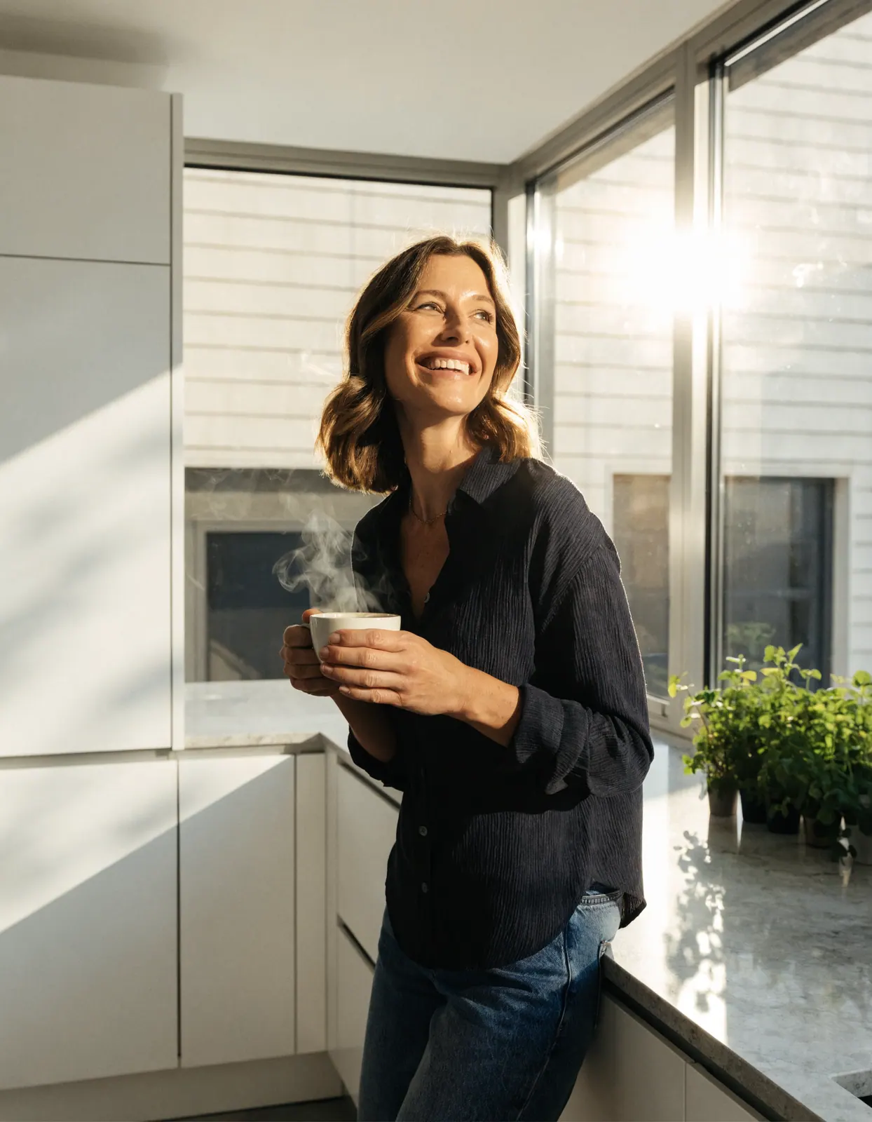 Vrouw met een kop koffie in haar keuken